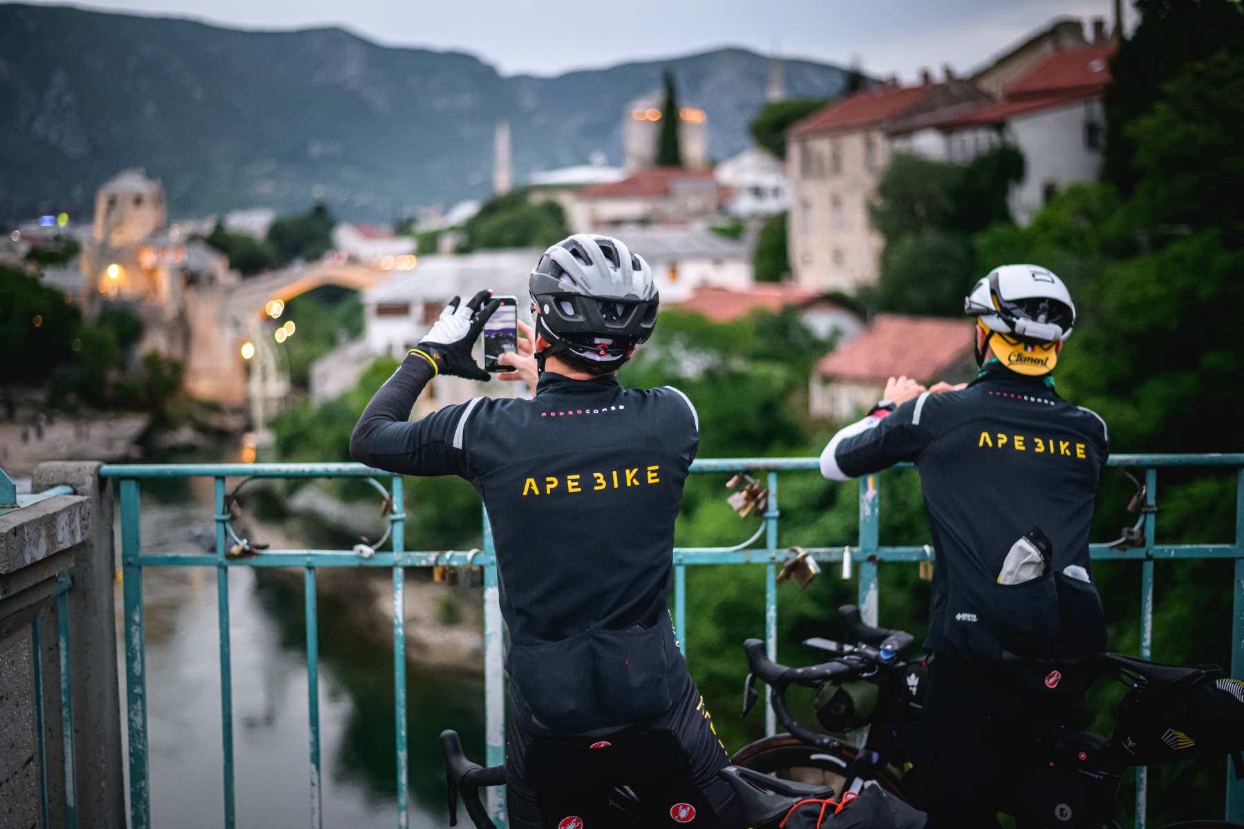 two cyclists taking a photo from a bridge in a city