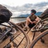 cyclist passing Mekong on a wooden boat